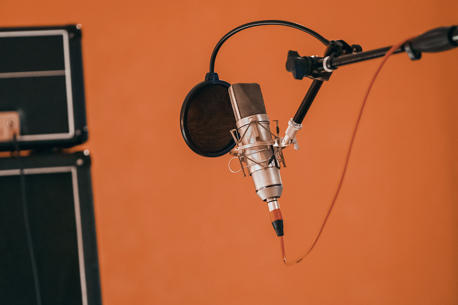 A professional microphone in front of an orange background